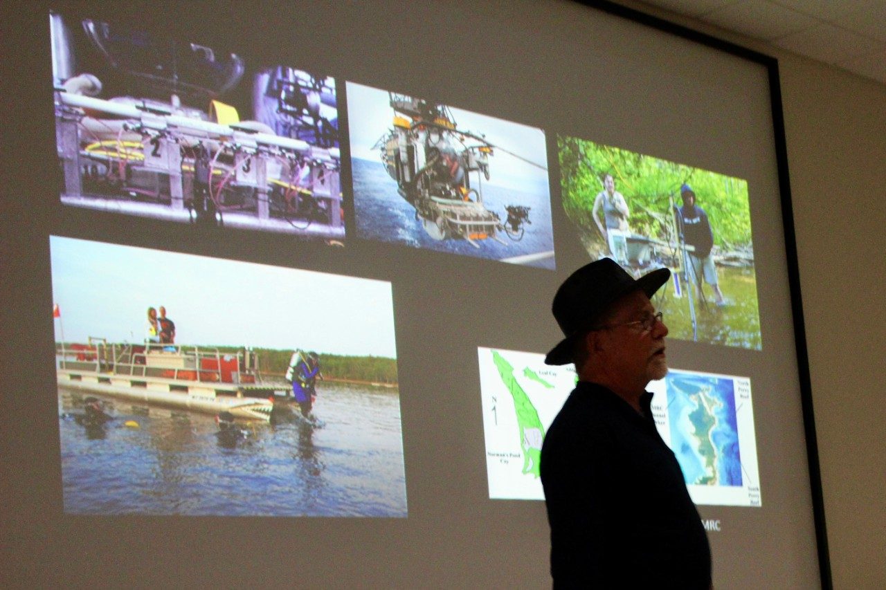 Man's silhouette in front of a screen with photos on it