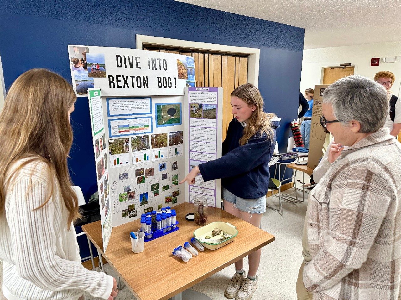 People looking at a poster presentation featuring photos