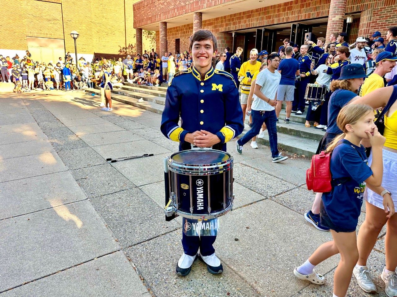 Person in a band uniform holding a drum