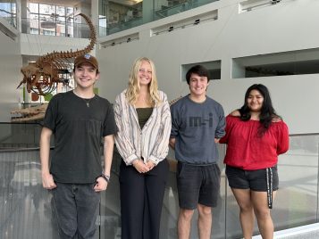Four people standing for a posed group photo