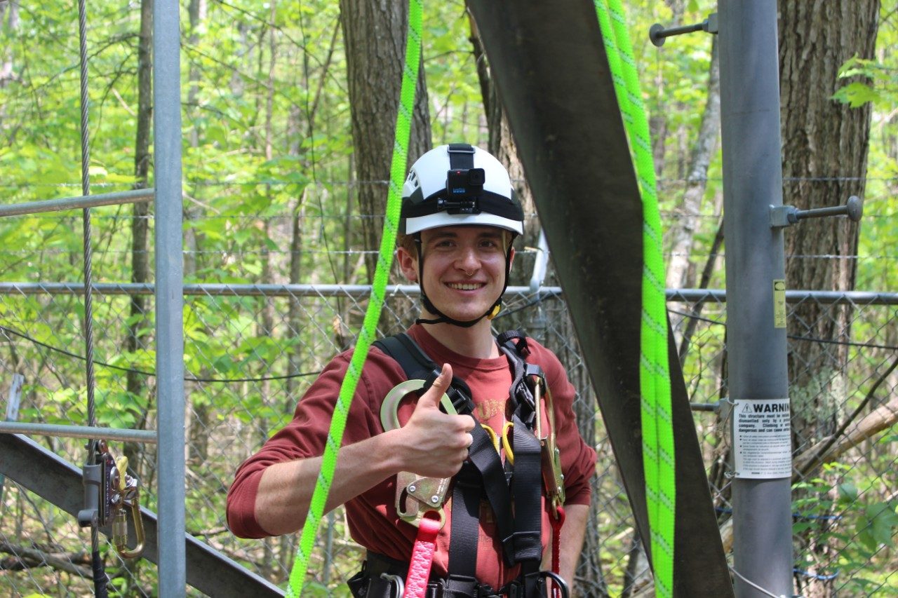 Person giving a thumbs-up in the forest