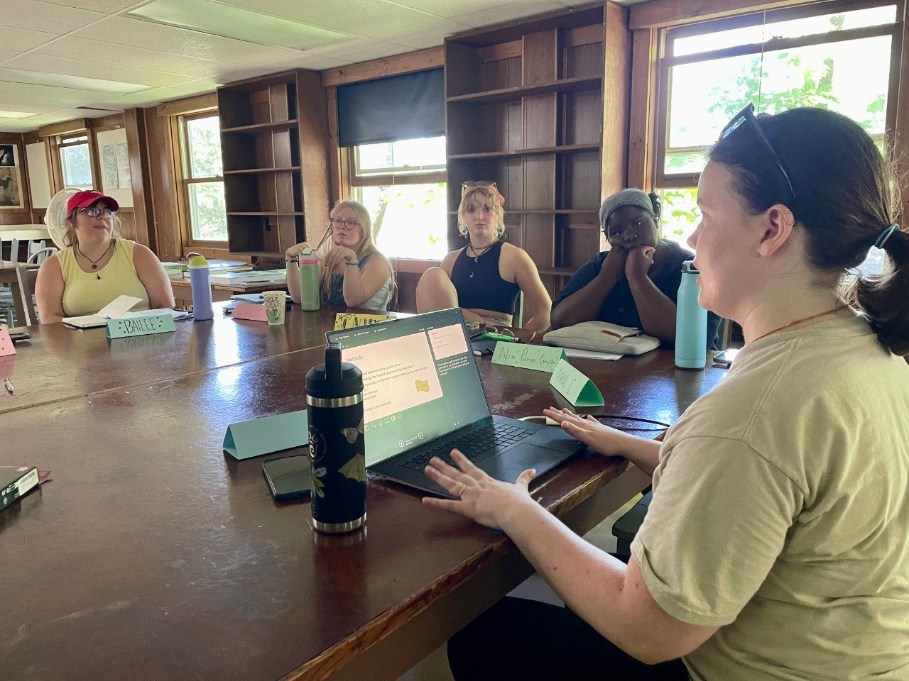 Woman sitting at a table teaching a class