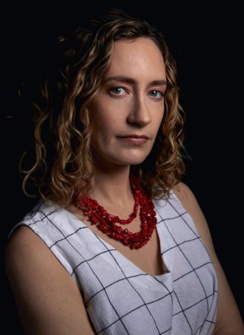 Head shot photo of a woman wearing a red necklace