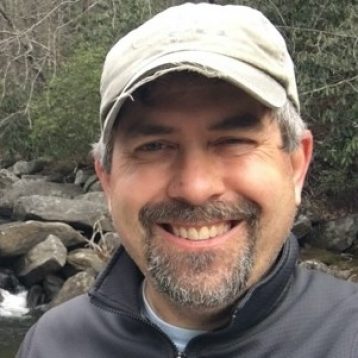 Head shot photo of a man standing outside