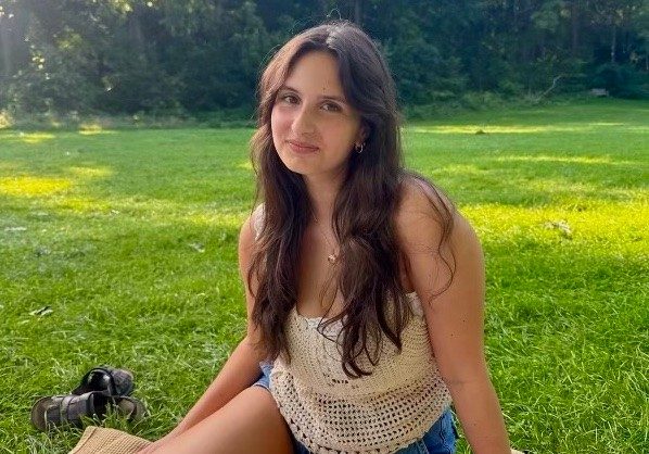 Woman smiling and sitting in grass