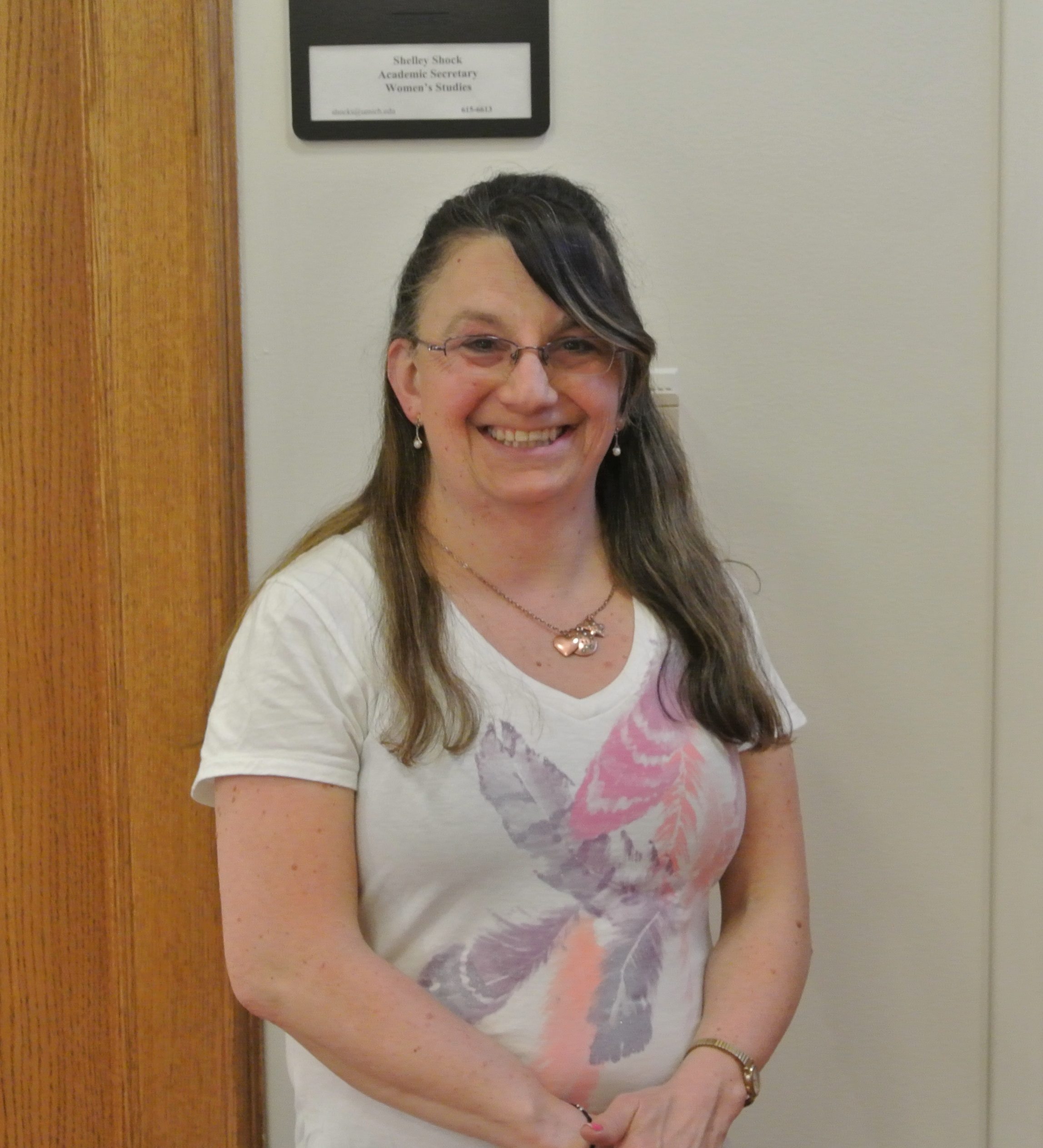 Shelley in a white shirt smiling against a neutral background